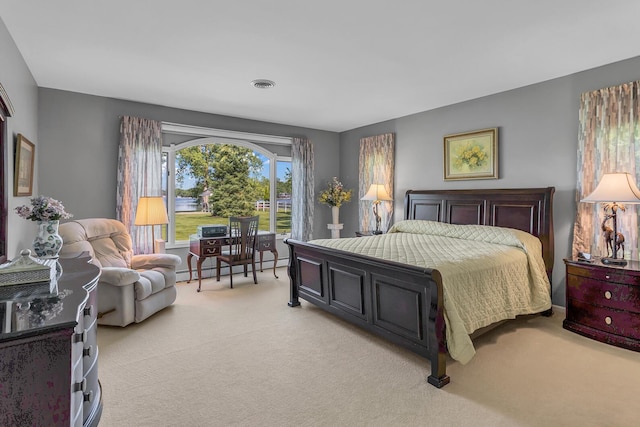 bedroom with a baseboard heating unit and light colored carpet