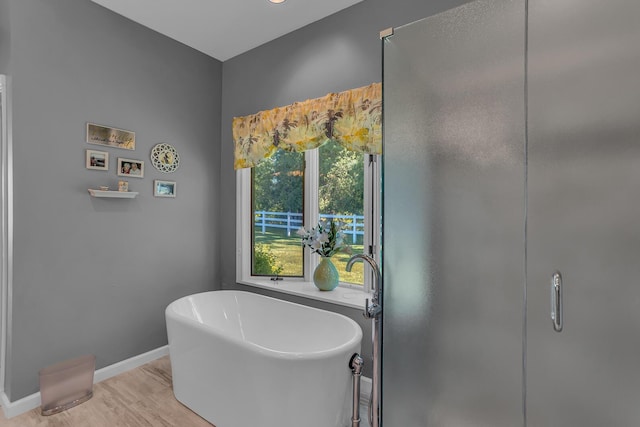 bathroom with wood-type flooring and a bathtub