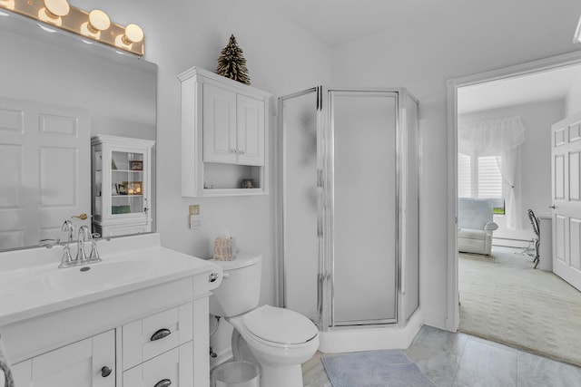 bathroom featuring vanity, a shower with shower door, and toilet