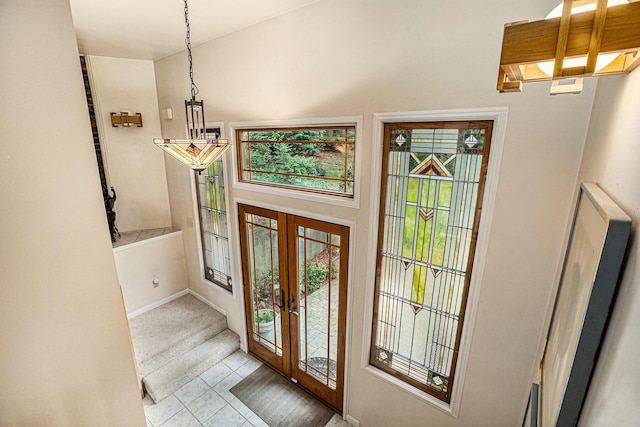 entrance foyer featuring french doors, light tile patterned floors, and plenty of natural light