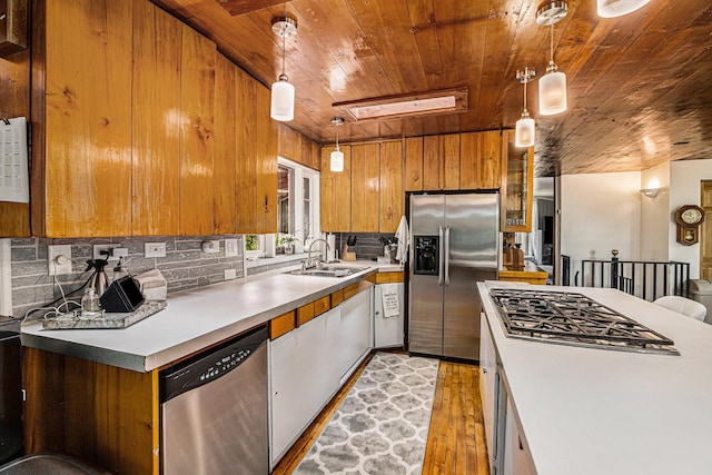 kitchen featuring decorative light fixtures, sink, wooden ceiling, and stainless steel appliances