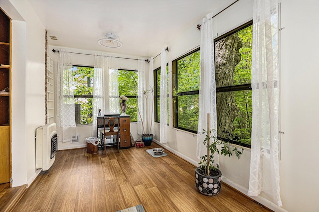 sunroom featuring a wealth of natural light and heating unit