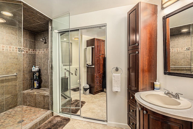 bathroom with tile patterned flooring, vanity, toilet, and walk in shower