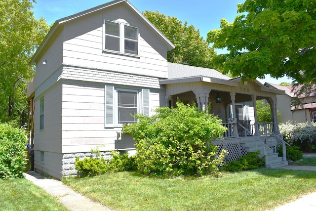 view of front of home with a porch and a front lawn