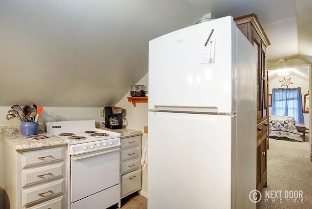 kitchen with carpet flooring, lofted ceiling, and white appliances