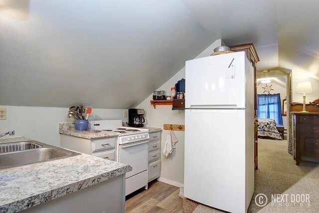 kitchen with white appliances, light hardwood / wood-style floors, lofted ceiling, and sink