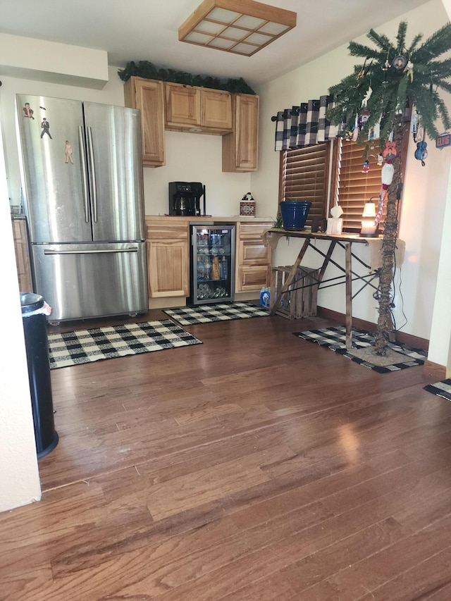 kitchen with light brown cabinets, stainless steel refrigerator, beverage cooler, and dark wood-type flooring