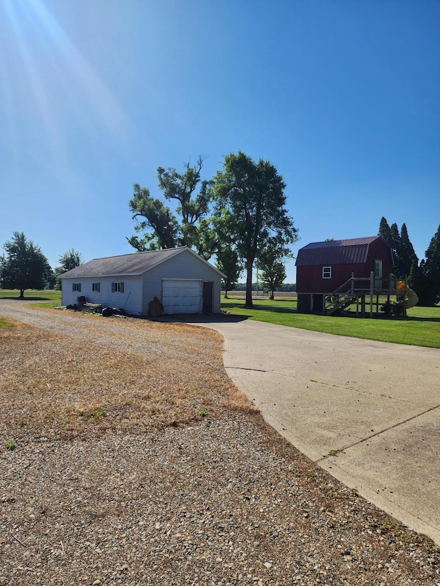 exterior space featuring a lawn, an outbuilding, and a garage