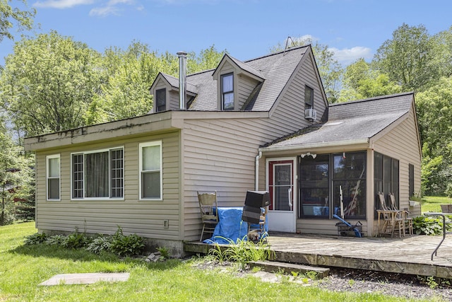 back of property featuring a sunroom, a yard, and a deck