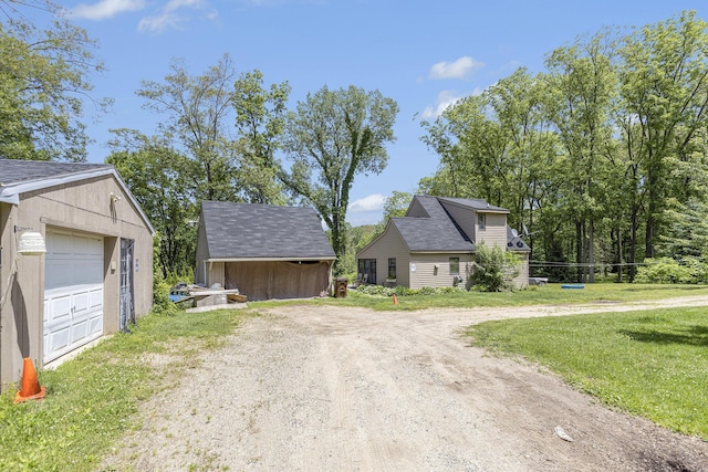 view of front of house with an outbuilding, a garage, and a front lawn