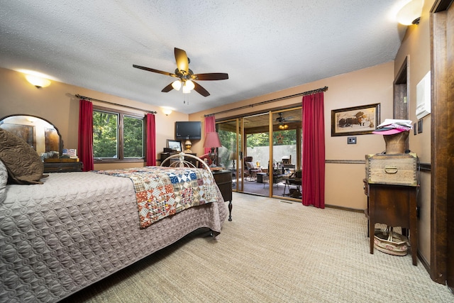 bedroom with access to exterior, a textured ceiling, light colored carpet, and ceiling fan