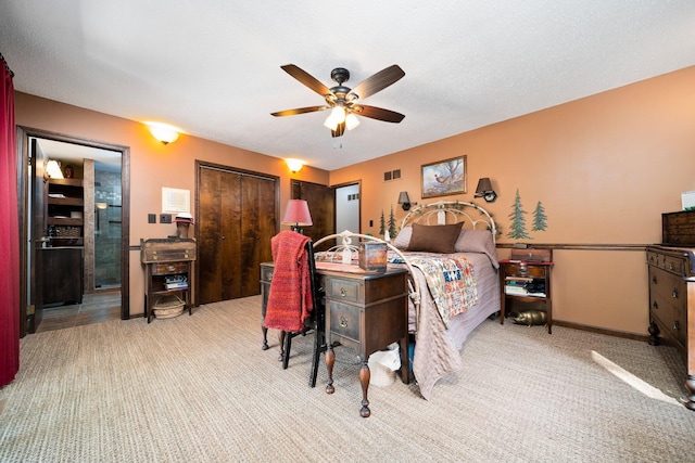 bedroom with ceiling fan, light colored carpet, a textured ceiling, and a closet