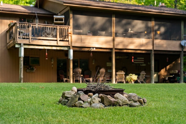 back of house featuring a lawn and a sunroom