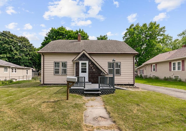 bungalow with a front lawn and a wooden deck