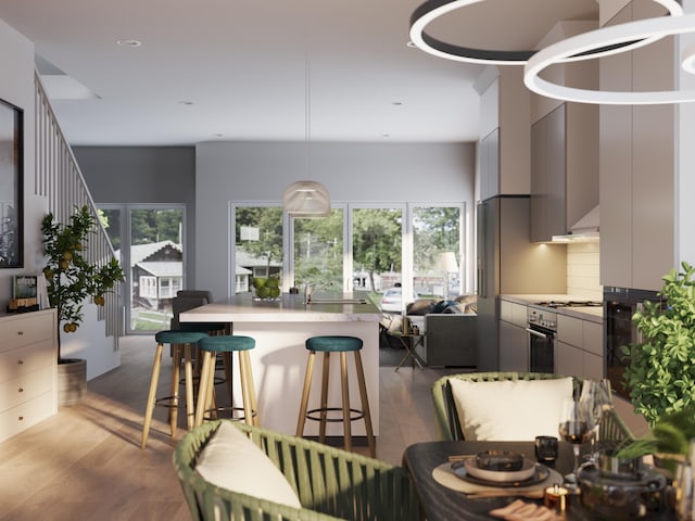 kitchen with wood-type flooring, a breakfast bar, a wealth of natural light, and stainless steel range