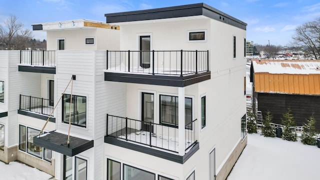 snow covered property featuring a balcony