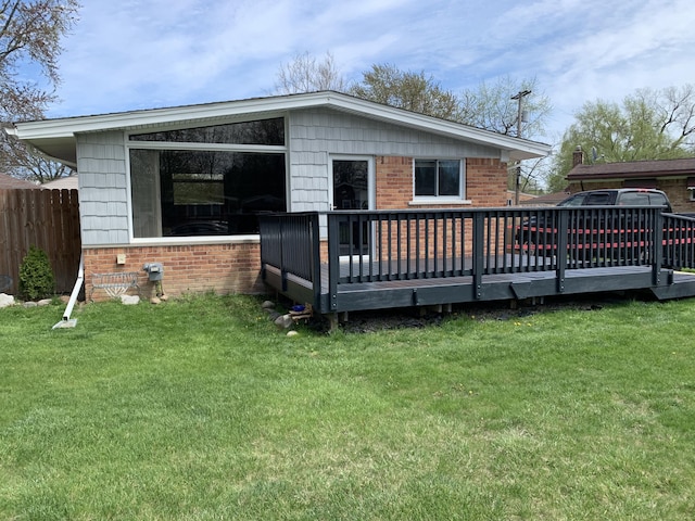 back of house with a wooden deck and a yard