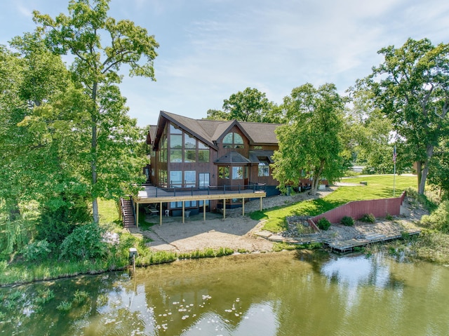 rear view of property featuring a water view and a yard