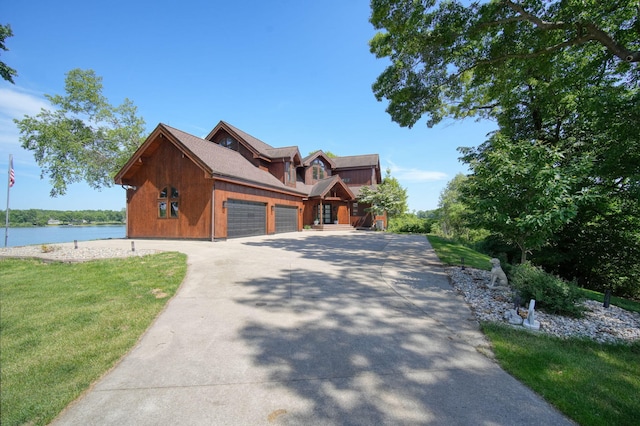 view of front of house featuring a water view, a garage, and a front yard