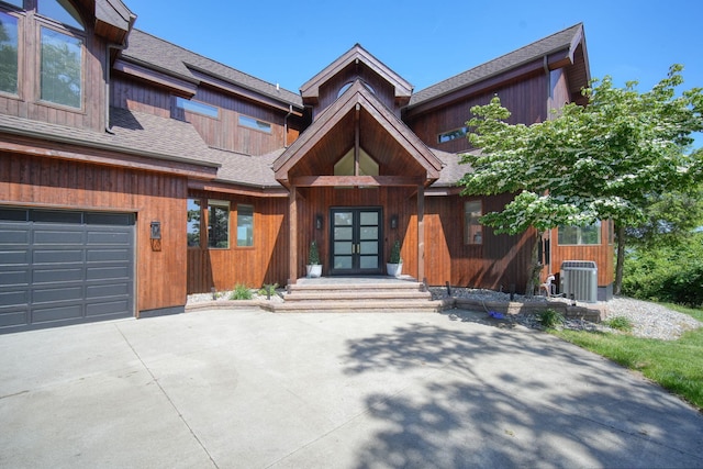 view of front of property featuring a garage and central air condition unit