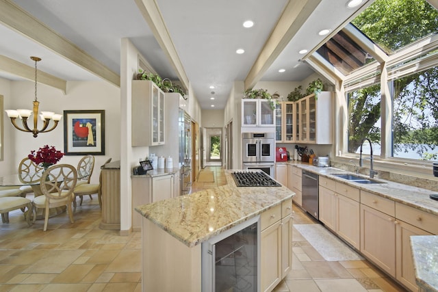 kitchen with sink, appliances with stainless steel finishes, a center island, beverage cooler, and beamed ceiling