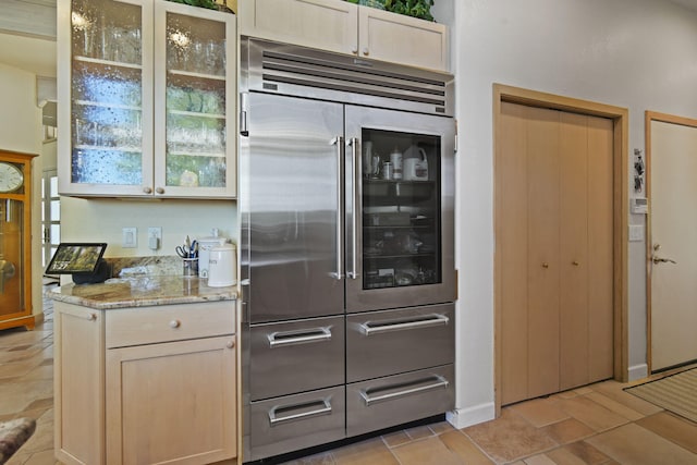 kitchen featuring light stone countertops and built in refrigerator