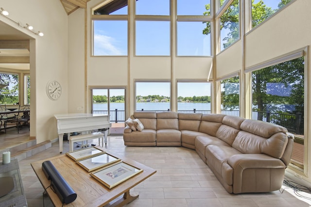 living room with a water view, a towering ceiling, and a wealth of natural light