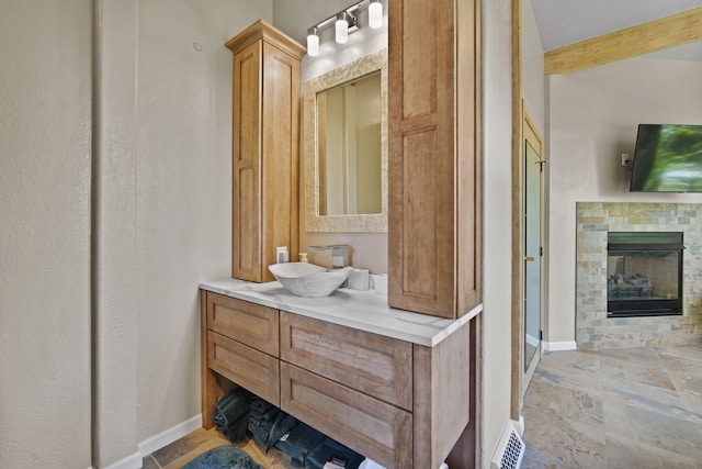 bathroom featuring a tile fireplace and vanity