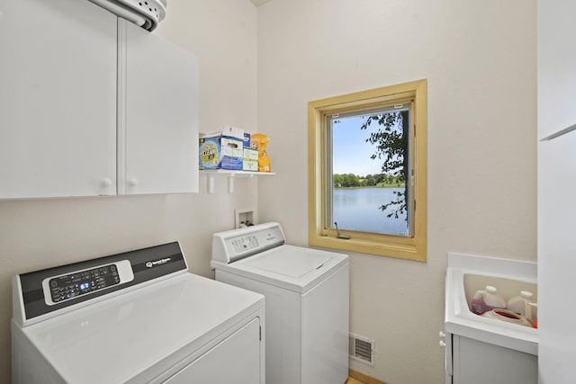 clothes washing area featuring cabinets and washer and dryer