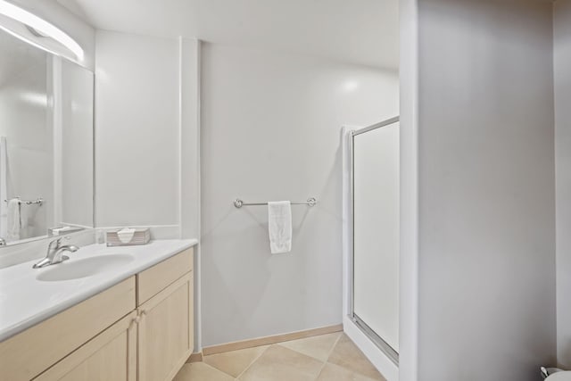 bathroom featuring a shower with door, vanity, and tile patterned flooring