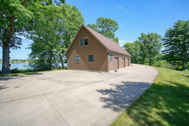 view of home's exterior featuring a garage and a water view