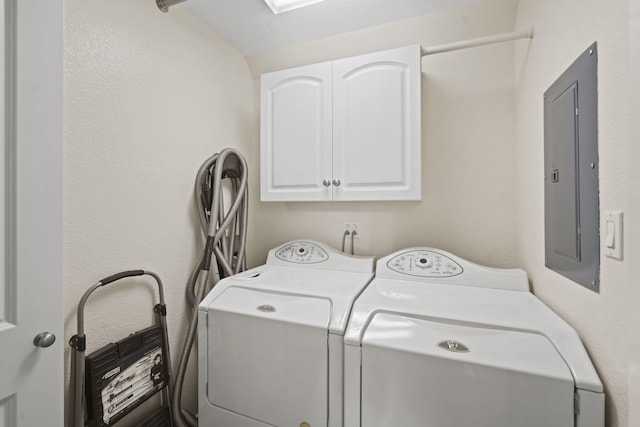 washroom with cabinets, electric panel, and washer and dryer