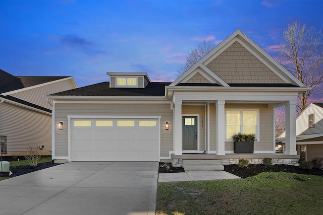 view of front of house with a porch, a garage, and a yard