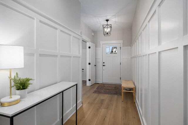 mudroom with a notable chandelier and light wood-type flooring