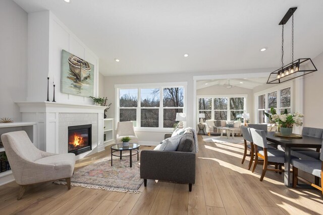 living room featuring vaulted ceiling, a healthy amount of sunlight, and light hardwood / wood-style floors