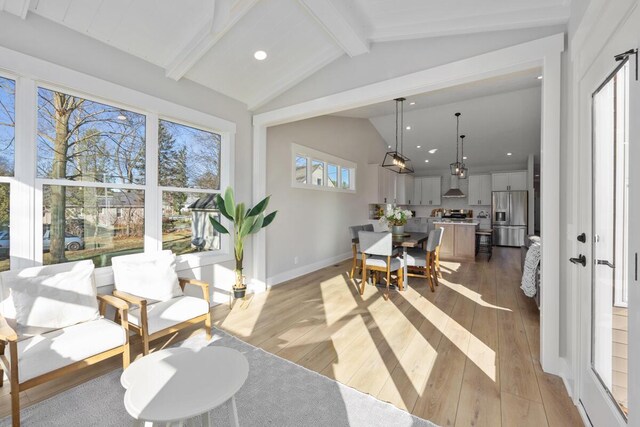 interior space featuring lofted ceiling with beams and light wood-type flooring