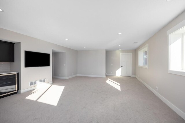 unfurnished living room featuring light carpet