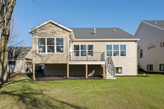 back of house with a wooden deck and a lawn