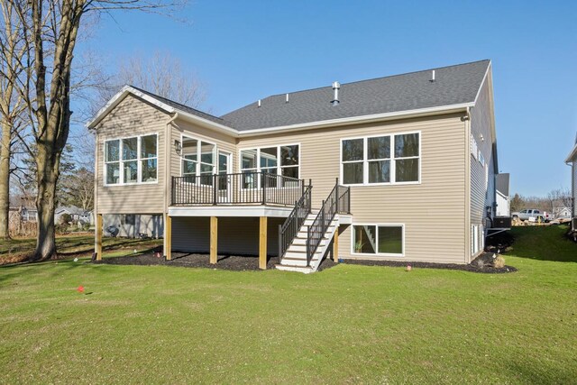 back of property featuring a wooden deck and a yard