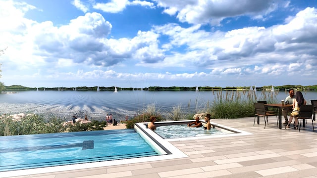 view of swimming pool featuring a patio and a water view