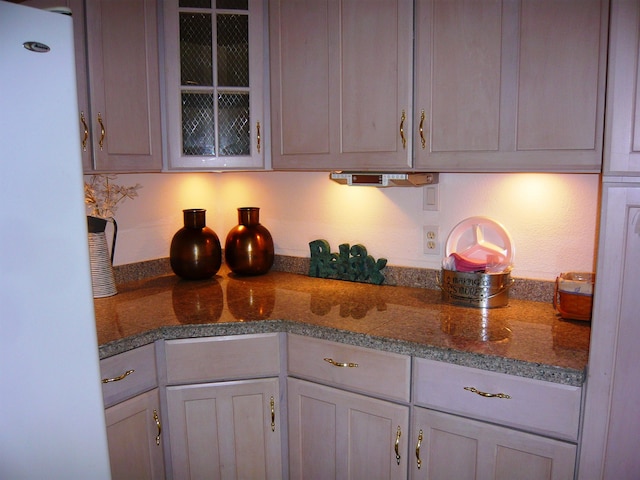 kitchen with stone counters and white fridge