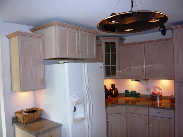 kitchen with decorative light fixtures and white refrigerator with ice dispenser