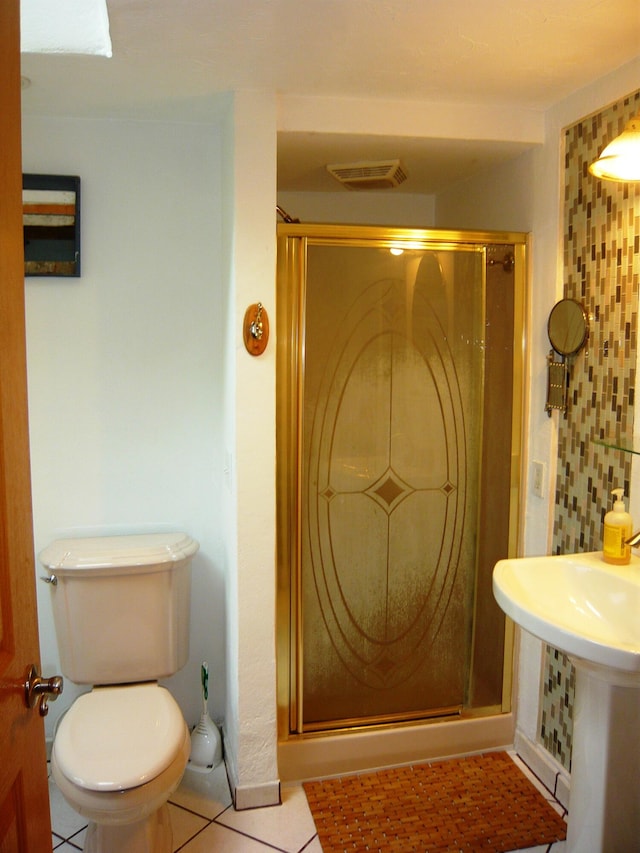 bathroom with toilet, a shower with shower door, tile patterned flooring, and backsplash