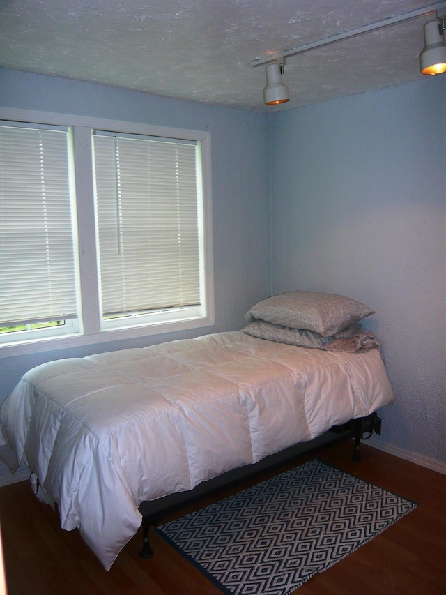 bedroom featuring hardwood / wood-style floors and a textured ceiling