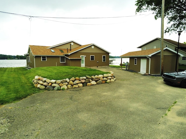 exterior space with a water view, a yard, and a shed