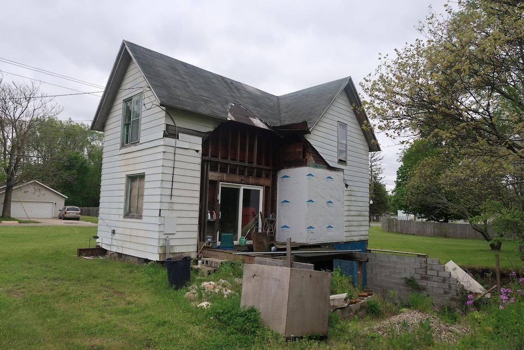 rear view of property featuring a yard