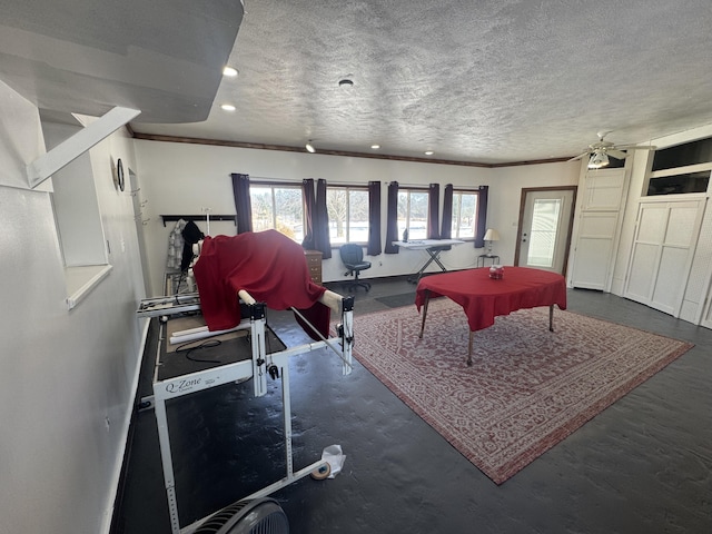 recreation room featuring crown molding and a textured ceiling