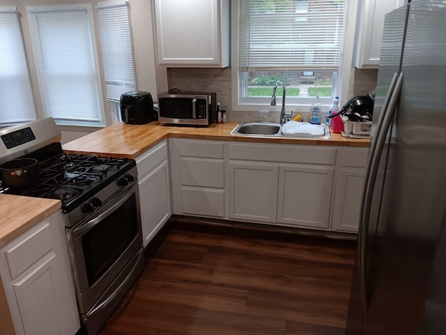 kitchen featuring wood counters, appliances with stainless steel finishes, sink, and white cabinets