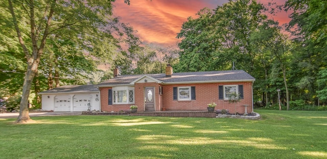 ranch-style house featuring driveway, a front lawn, an attached garage, brick siding, and a chimney