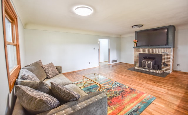 living room featuring hardwood / wood-style floors and a wood stove